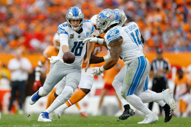 TAMPA, FLORIDA - OCTOBER 15: Jared Goff #16 of the Detroit Lions hands the ball off to Craig Reynolds #13 of the Detroit Lions during the third quarter against the Tampa Bay Buccaneers at Raymond James Stadium on October 15, 2023 in Tampa, Florida.