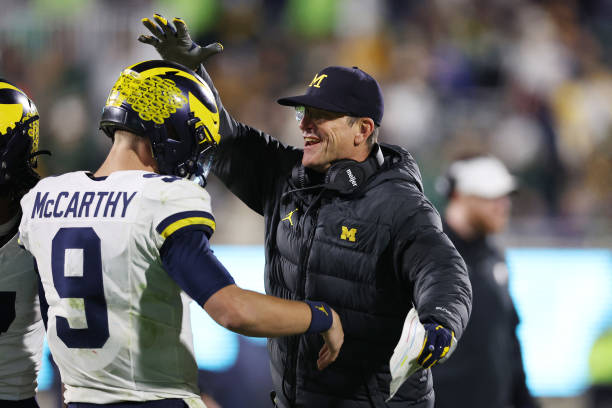 EAST LANSING, MICHIGAN - OCTOBER 21: Head coach Jim Harbaugh of the Michigan Wolverines congratulates J.J. McCarthy #9 after one of his second half touchdown passes while playing the Michigan State Spartans at Spartan Stadium on October 21, 2023 in East Lansing, Michigan. (Photo by Gregory Shamus/Getty Images)